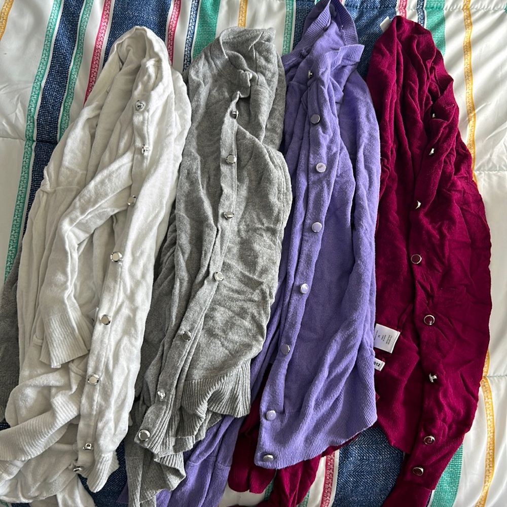 Pink and purple long sleeve sweaters and grey and white 3/4 sleeve cardigans.
